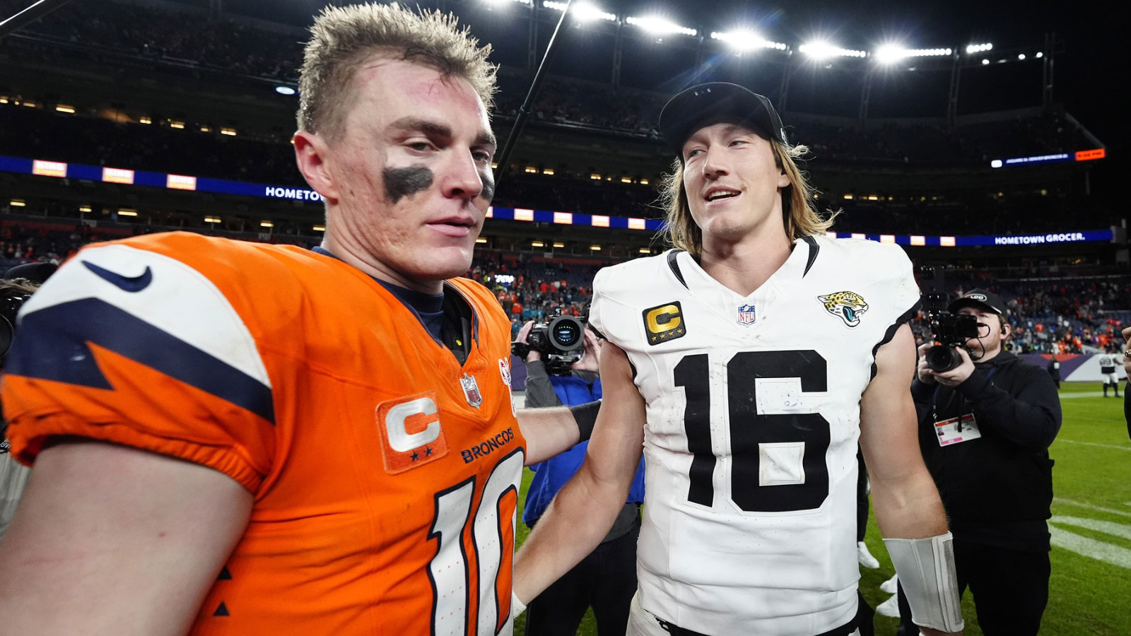 Dec 21, 2025; Denver, Colorado, USA; Denver Broncos quarterback Bo Nix (10) and Jacksonville Jaguars quarterback Trevor Lawrence (16) meet after the game at Empower Field at Mile High. Mandatory Credit: Ron Chenoy-Imagn Images