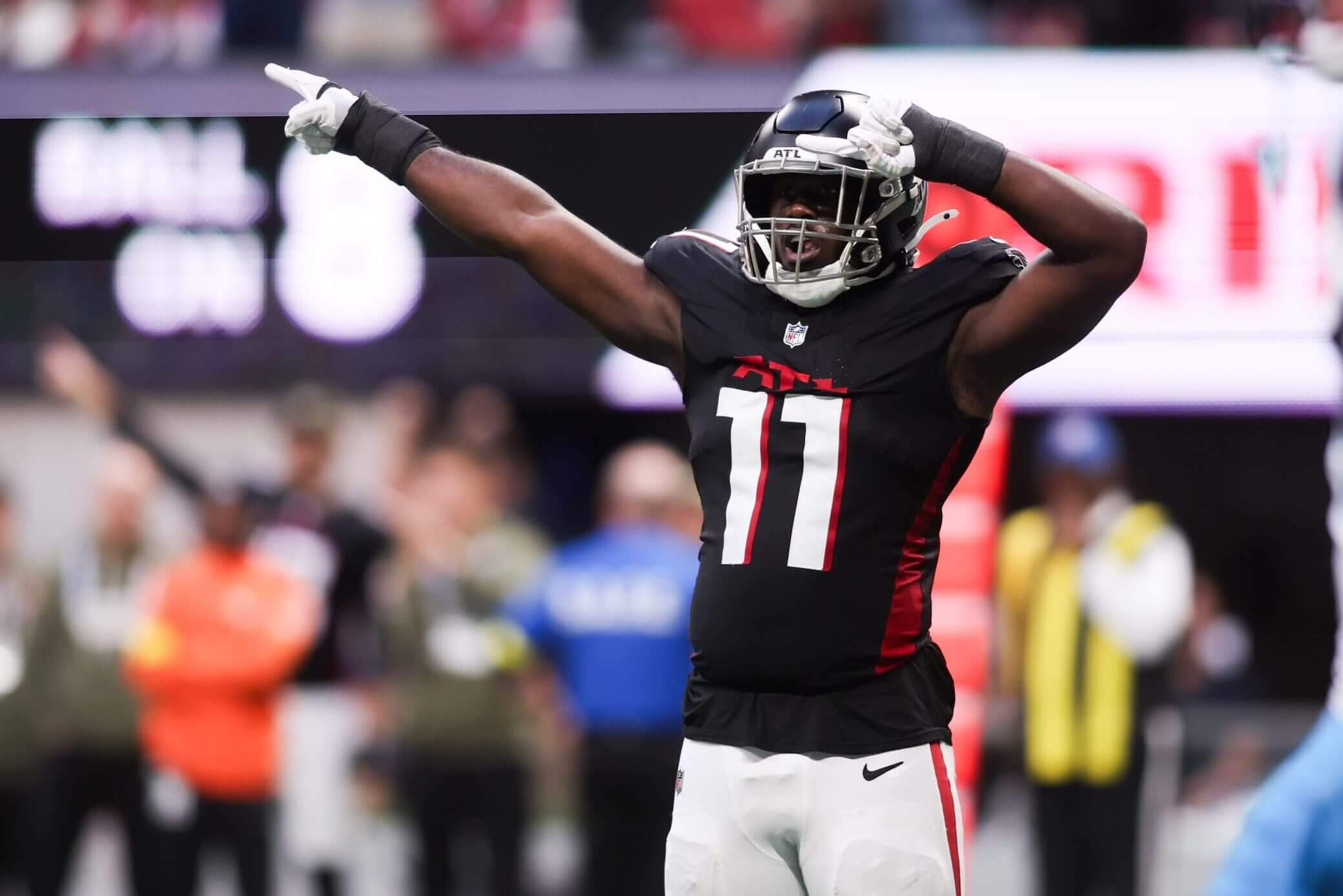 Atlanta Falcons edge rusher Jalon Walker (11) points with both arms to his right after a play against the Carolina Panthers at Mercedes-Benz Stadium.