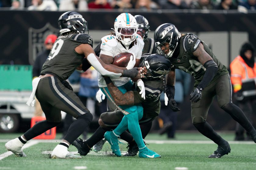 Miami Dolphins running back Jaylen Wright (5) is tackled by a group of New York Jets players during a week 14 football game between the New York Jets and Miami Dolphins at MetLife Stadium on Sunday, Dec. 7, 2025.
