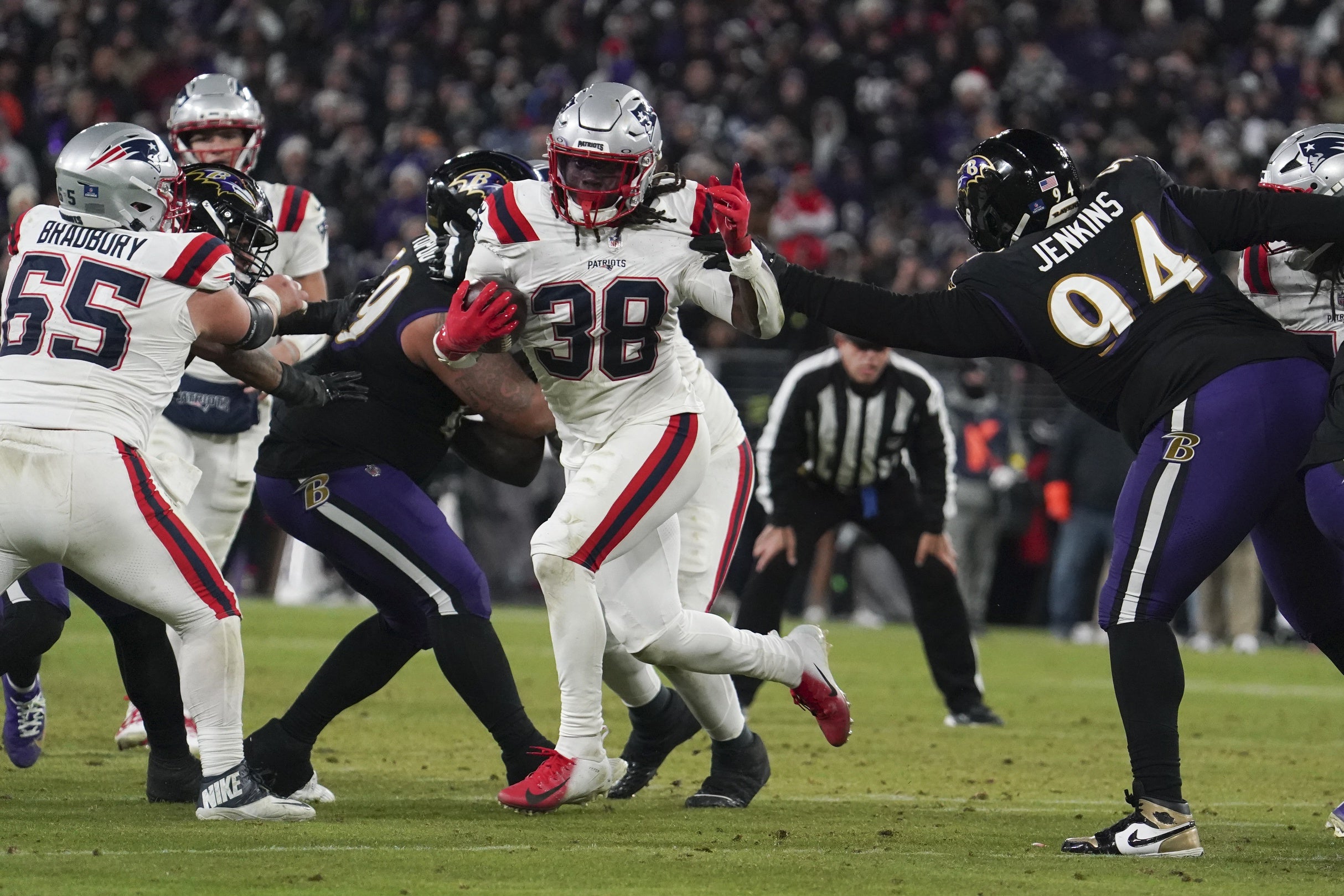 Dec 21, 2025; Baltimore, Maryland, USA; New England Patriots running back Rhamondre Stevenson (38) runs for a touchdown against Baltimore Ravens defensive tackle John Jenkins (94) during the second half of the game at M&T Bank Stadium.