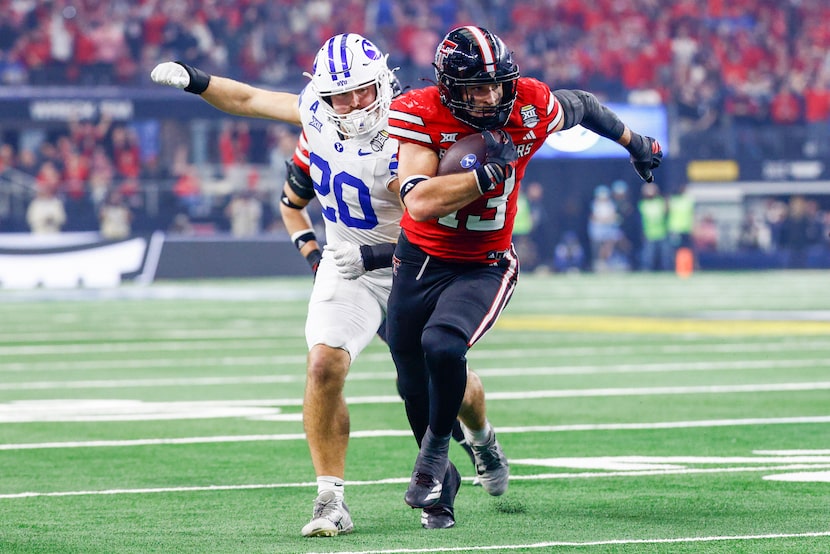 Texas Tech linebacker Ben Roberts (13) returns an interception ahead of BYU cornerback...