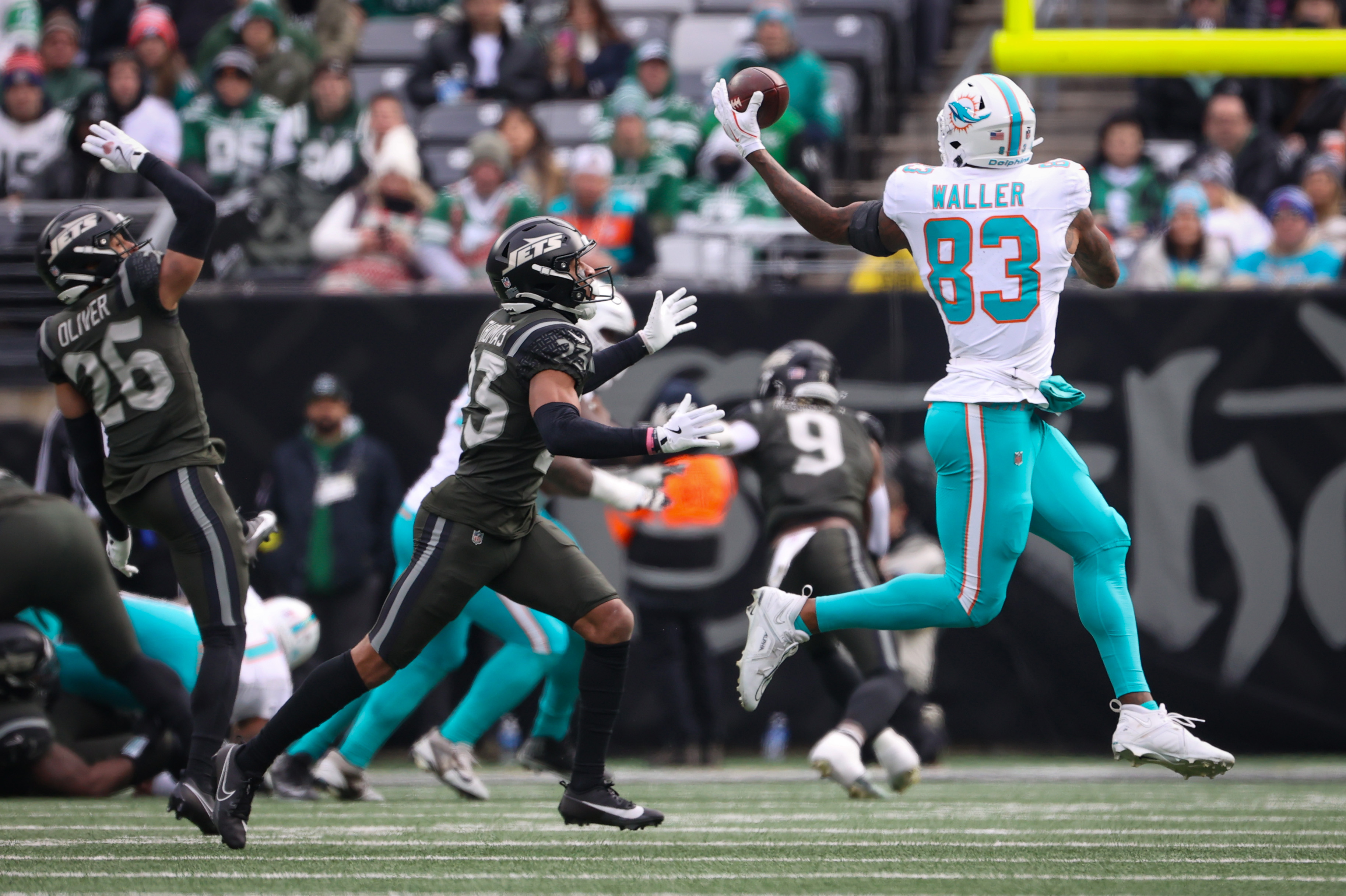 Miami Dolphins tight end Darren Waller (83) reaches for a pass thrown behind him as New York Jets cornerback Azareye'H Thomas (23) defends during the first half, Sunday, Dec. 7, 2025 at MetLife Stadium in East Rutherford, N.J.
