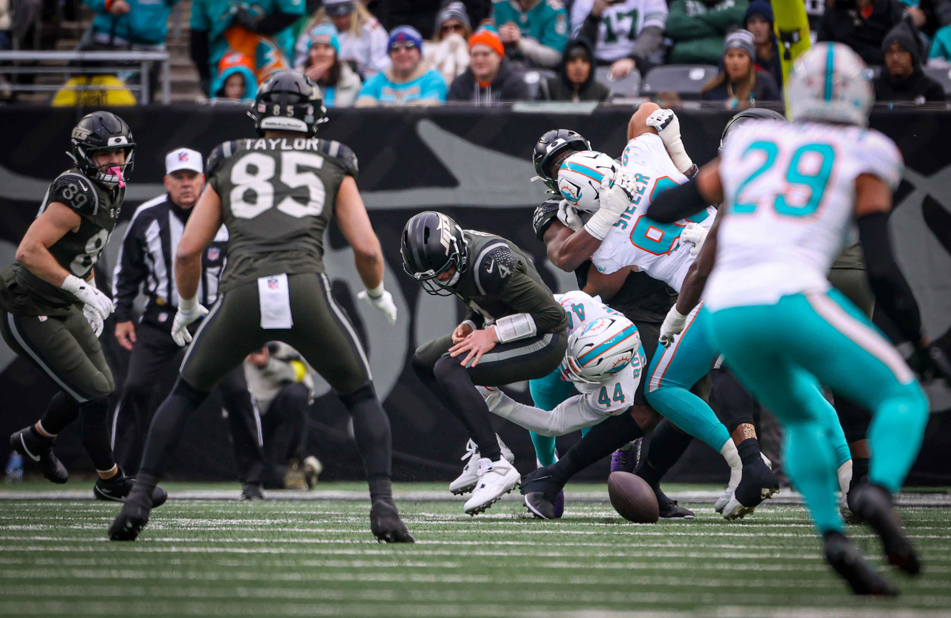New York Jets rookie quarterback Brady Cook (4) loses the ball as he his hit by Miami Dolphins linebacker Chop Robinson (44) during the second quarter, Sunday, Dec. 7, 2025 at MetLife Stadium in East Rutherford, N.J.