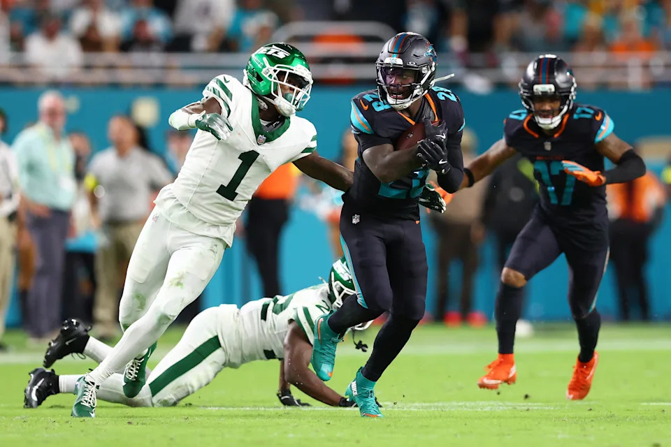 MIAMI GARDENS, FLORIDA - SEPTEMBER 29: De'Von Achane #28 of the Miami Dolphins is pursued by Sauce Gardner #1 of the New York Jets during the fourth quarter at Hard Rock Stadium on September 29, 2025 in Miami Gardens, Florida. (Photo by Megan Briggs/Getty Images)