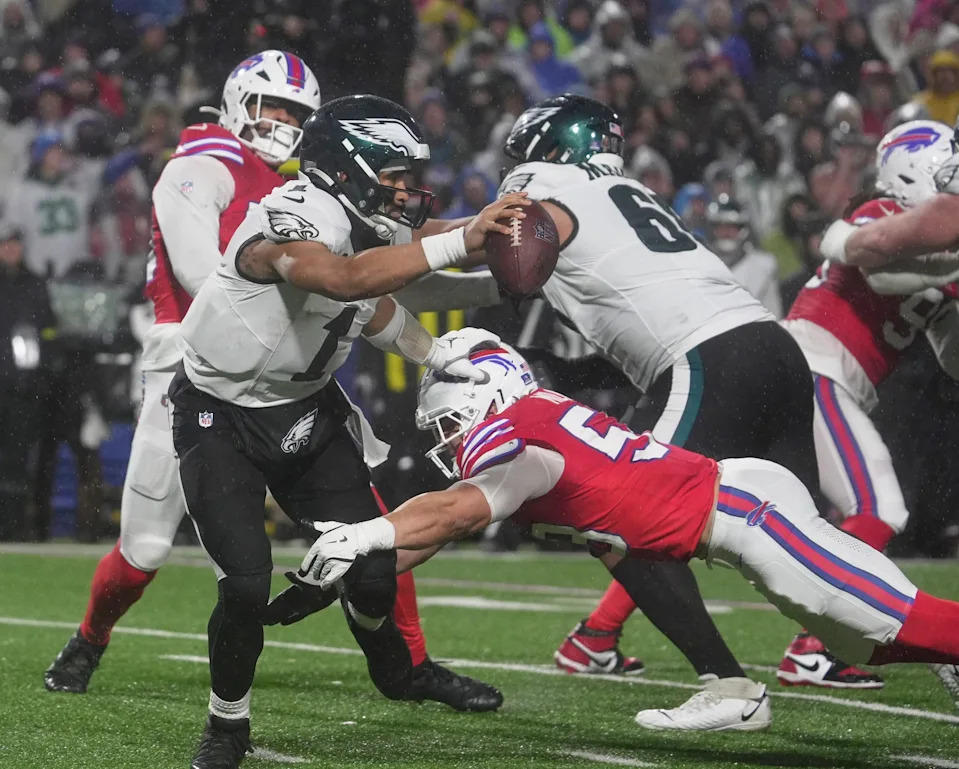 Philadelphia Eagles quarterback Jalen Hurts pushes away Buffalo Bills linebacker Matt Milano who almost got a hold of him during second half action against the Philadelphia Eagles at Highmark Stadium in Orchard Park on Dec. 28, 2025.