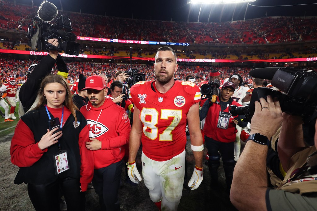 Travis Kelce of the Kansas City Chiefs walks off the field with media and staff after a 20-13 loss to the Denver Broncos.