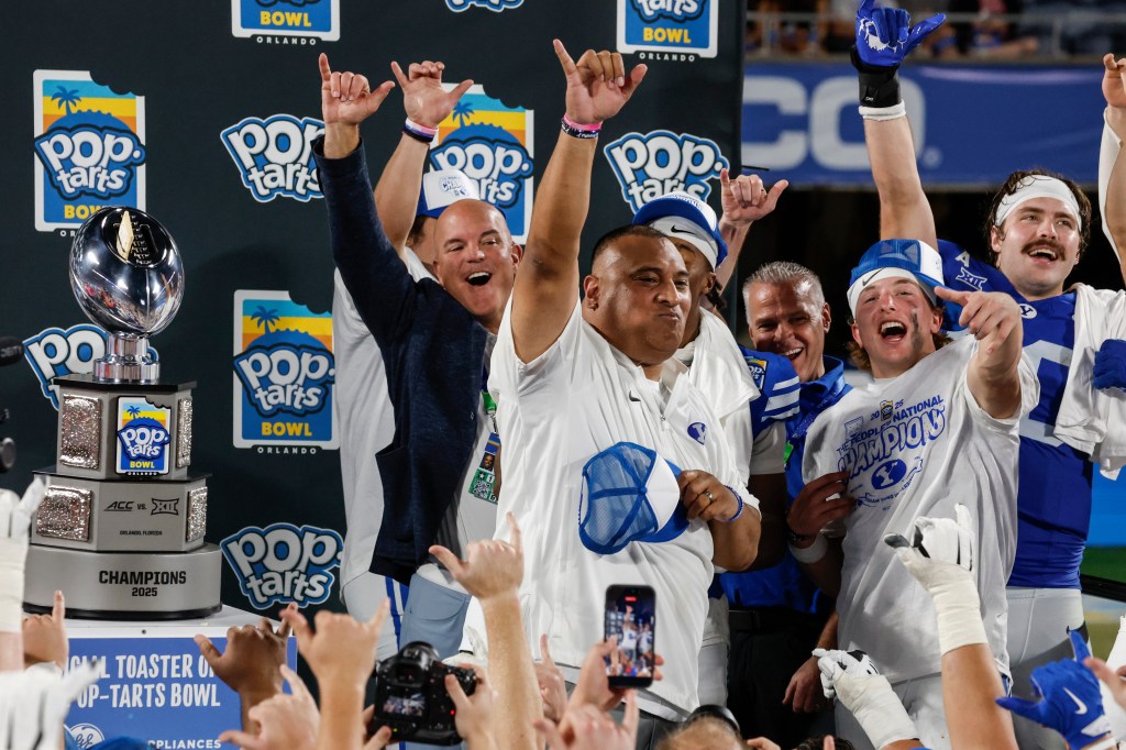 BYU head coach Kalani Sitake eats a Pop-Tart during the trophy presentation after winning the Pop-Tarts Bowl college football game.