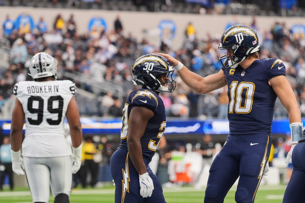Los Angeles Chargers running back Kimani Vidal (30) celebrates with quarterback Justin Herbert (10) after scoring a touchdown against the Las Vegas Raiders.