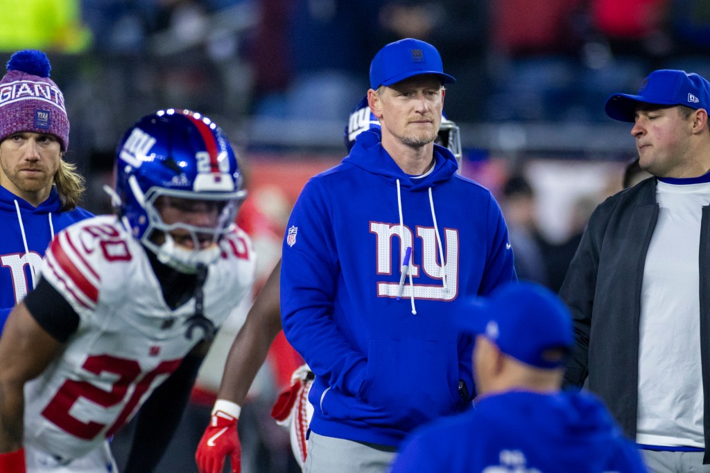 New York Giants interim defensive coordinator Charlie Bullen in a blue hoodie and cap on the field.