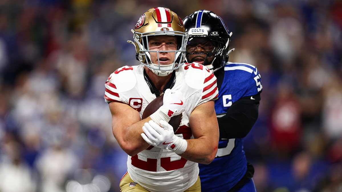 Christian McCaffrey runs with football