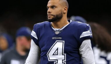 A football player in a blue Cowboys jersey with number 4 stands on the field.
