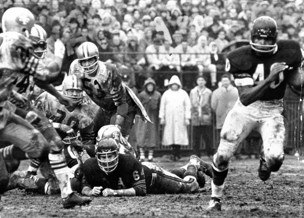 Gale Sayers, the "Kansas Comet," is all business as he eludes the San Francisco 49ers defense on the way to a 21-yard touchdown run on Dec. 12, 1965, one of six for the afternoon. Mike Rabold, however, thinks it's a barrel of laughs as he piles up three 49er defenders. Mike Dowdle (53) and Charle Krueger (70) of San Francisco aren't laughing, though. (Chicago Tribune historical photo)