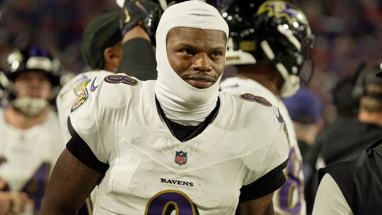 Baltimore Ravens quarterback Lamar Jackson (8) passes as head coach John Harbaugh looks prior to the game against the Los Angeles Chargers in a AFC Wild Card playoff football game at M&T Bank Stadium.