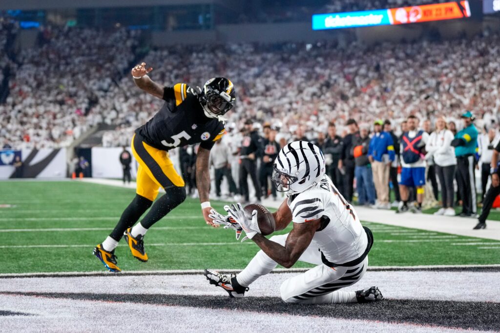 Cincinnati Bengals wide receiver Ja'Marr Chase (1) catches a pass under pressure from Pittsburgh Steelers cornerback Jalen Ramsey