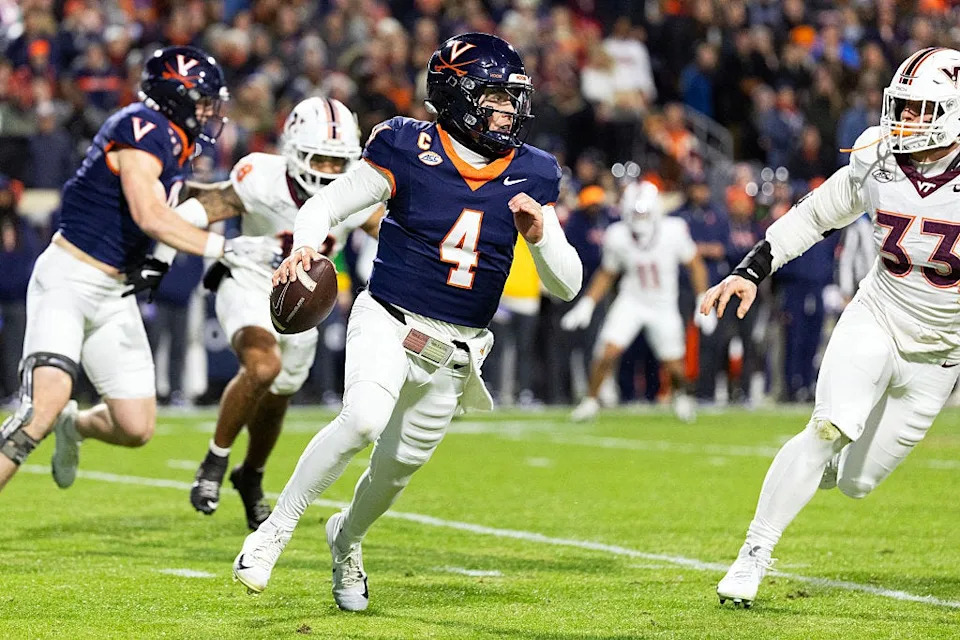 CHARLOTTESVILLE, VIRGINIA - NOVEMBER 29: Chandler Morris #4 of the Virginia Cavaliers scrambles away from Ben Bell #33 of the Virginia Tech Hokies in the first half during a game at Scott Stadium on November 29, 2025 in Charlottesville, Virginia. (Photo by Ryan M. Kelly/Getty Images)