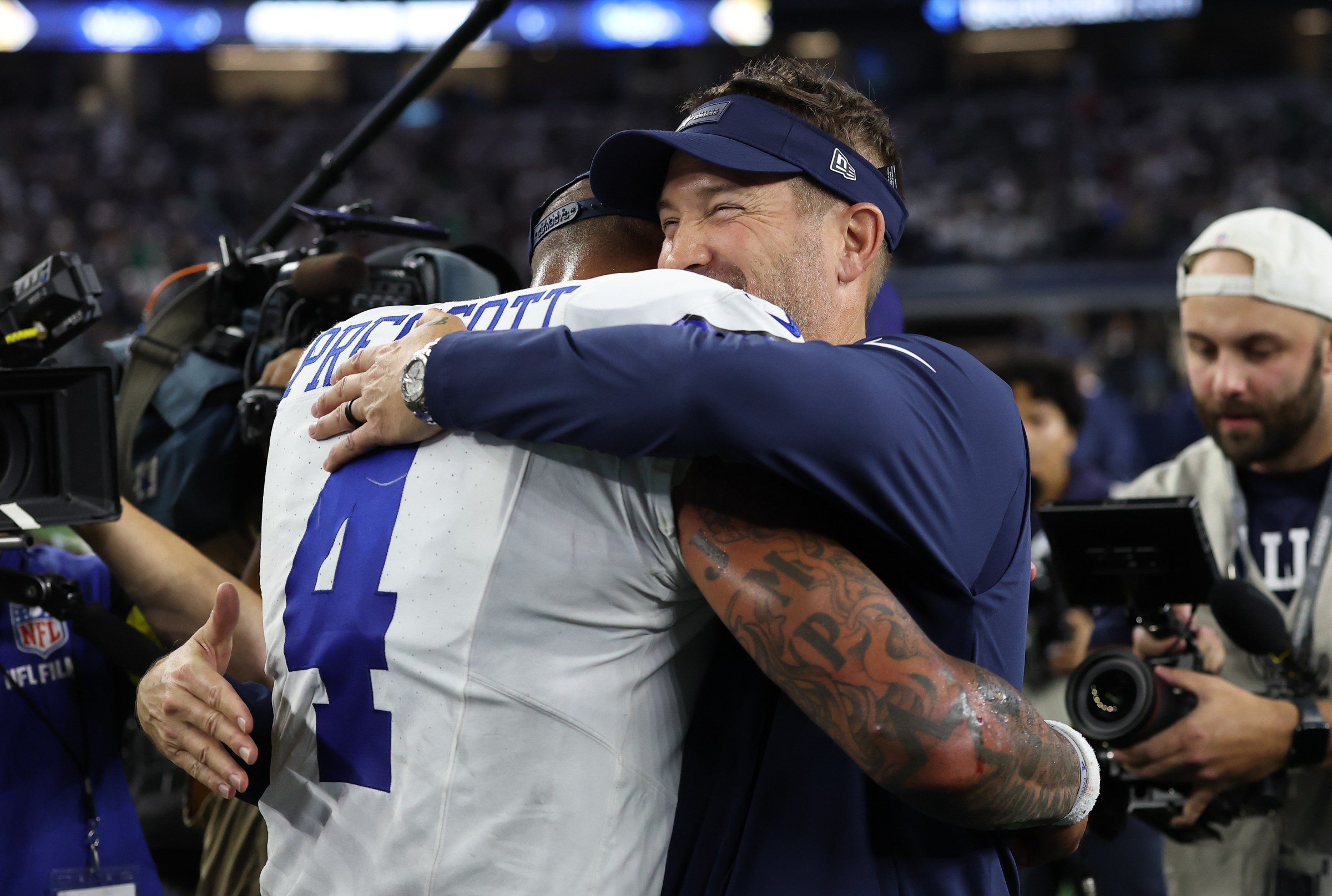 ARLINGTON, TEXAS - NOVEMBER 23: Dak Prescott #4 and Brian Schottenheimer of the Dallas Cowboys hug after the game against the Philadelphia Eagles in the game at AT&T Stadium on November 23, 2025 in Arlington, Texas. The Cowboys won 24-21. (Photo by Stacy Revere/Getty Images)