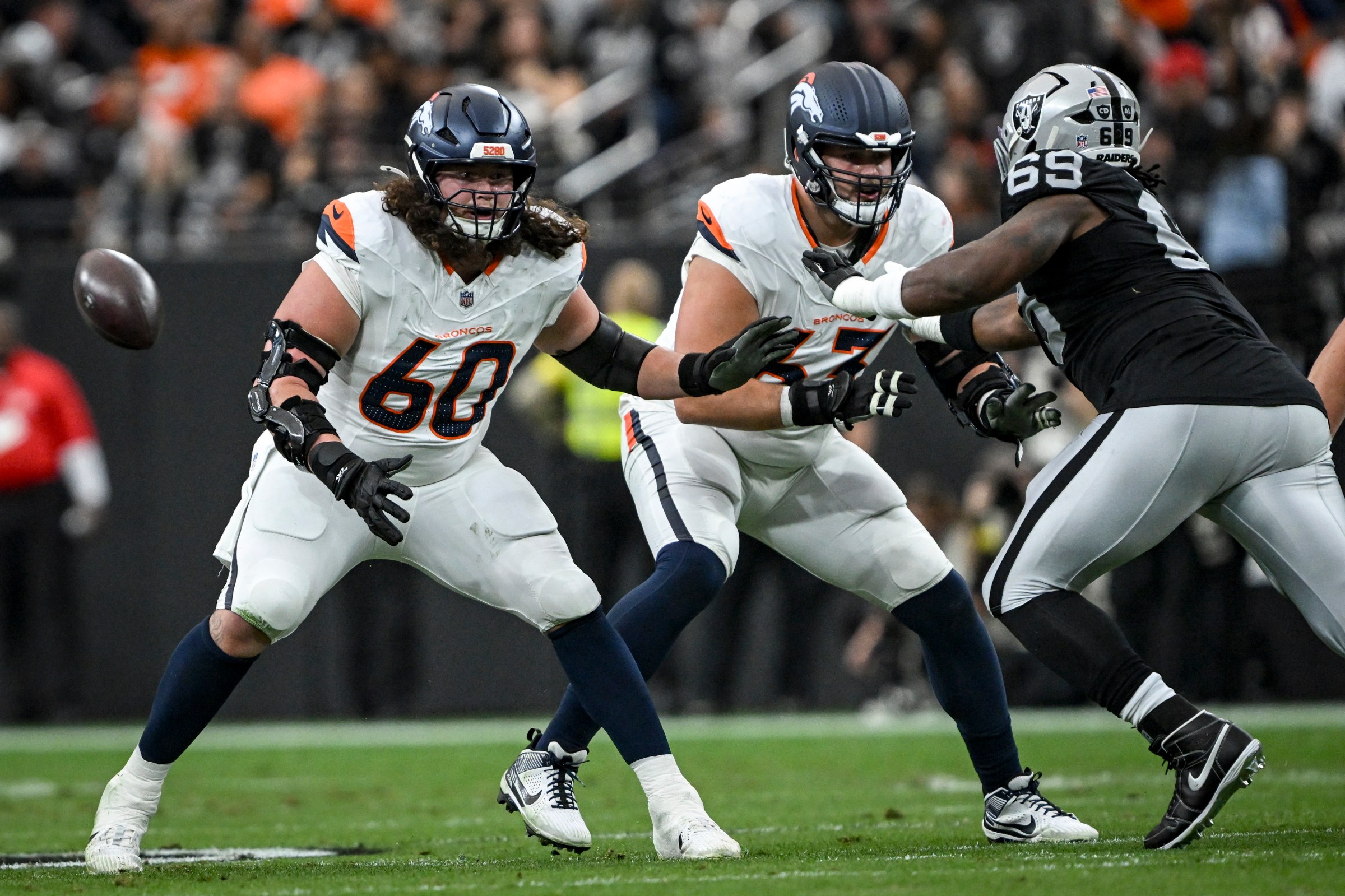 LAS VEGAS , NV - DECEMBER 7: Luke Wattenberg (60) and Alex Palczewski (63) of the Denver Broncos block Adam Butler (69) of the Las Vegas Raiders during the first quarter at Allegiant Stadium in Las Vegas, Nevada on Sunday, December 7, 2025. (Photo by AAron Ontiveroz/The Denver Post)