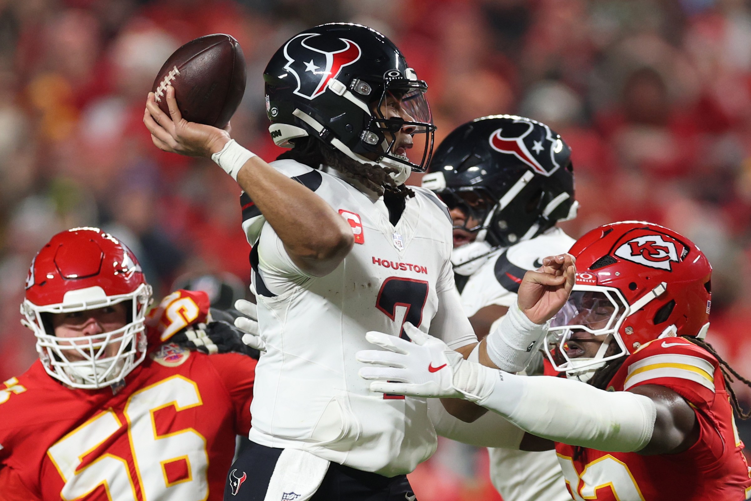 KANSAS CITY, MISSOURI - DECEMBER 07: C.J. Stroud #7 of the Houston Texans throws a touchdown pass while being pressured by George Karlaftis #56 and Nick Bolton #32 of the Kansas City Chiefs during the second quarter at Arrowhead Stadium on December 07, 2025 in Kansas City, Missouri. (Photo by Jamie Squire/Getty Images)