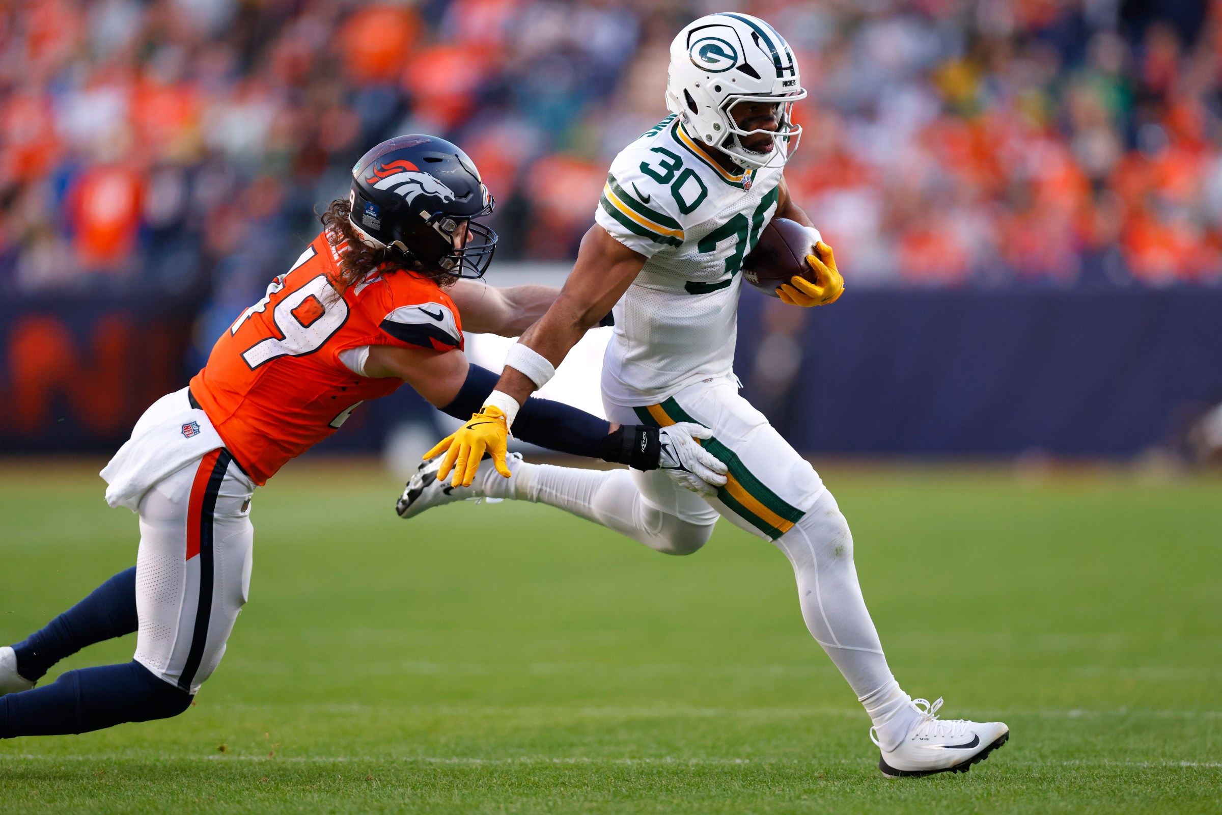 DENVER, COLORADO - DECEMBER 14: Chris Brooks #30 of the Green Bay Packers catches a pass against Alex Singleton #49 of the Denver Broncos during the second quarter at Empower Field At Mile High on December 14, 2025 in Denver, Colorado. (Photo by Justin Edmonds/Getty Images)