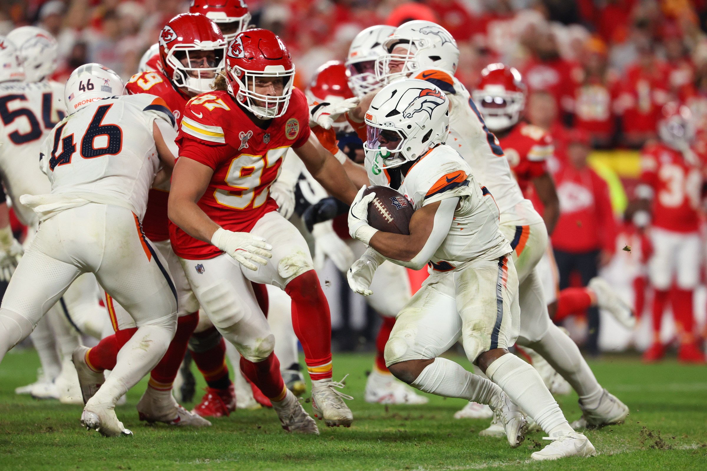 KANSAS CITY, MISSOURI - DECEMBER 25: RJ Harvey #12 of the Denver Broncos carries the ball against Ashton Gillotte #97 of the Kansas City Chiefs during the fourth quarter at Arrowhead Stadium on December 25, 2025 in Kansas City, Missouri. (Photo by Eric Thomas/Getty Images)