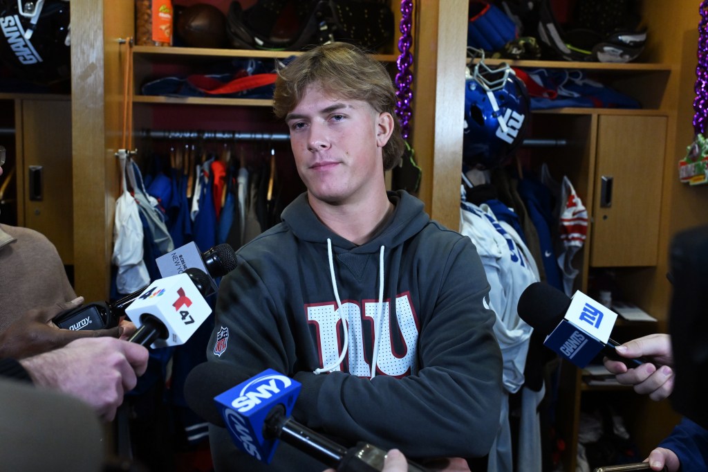 Giants quarterback Jaxson Dart speaking to the media in a locker room setting.