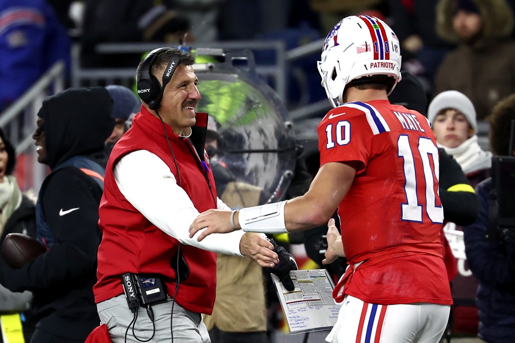 New England Patriots head coach Mike Vrabel shaking hands with quarterback Drake Maye during a game against the New York Giants.