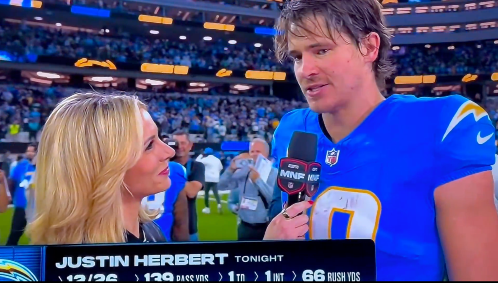 Justin Herbert giving an interview on the field after the game.