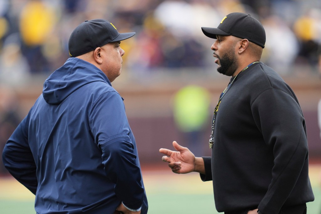 Warde Manuel, left, talks with head coach Sherrone Moore, right, before an NCAA college football spring game in Ann Arbor, Mich., April 19, 2025.