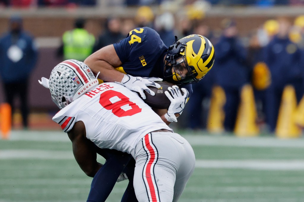 Michigan Wolverines running back Bryson Kuzdzal (24) is tackled by Ohio State Buckeyes linebacker Arvell Reese (8).