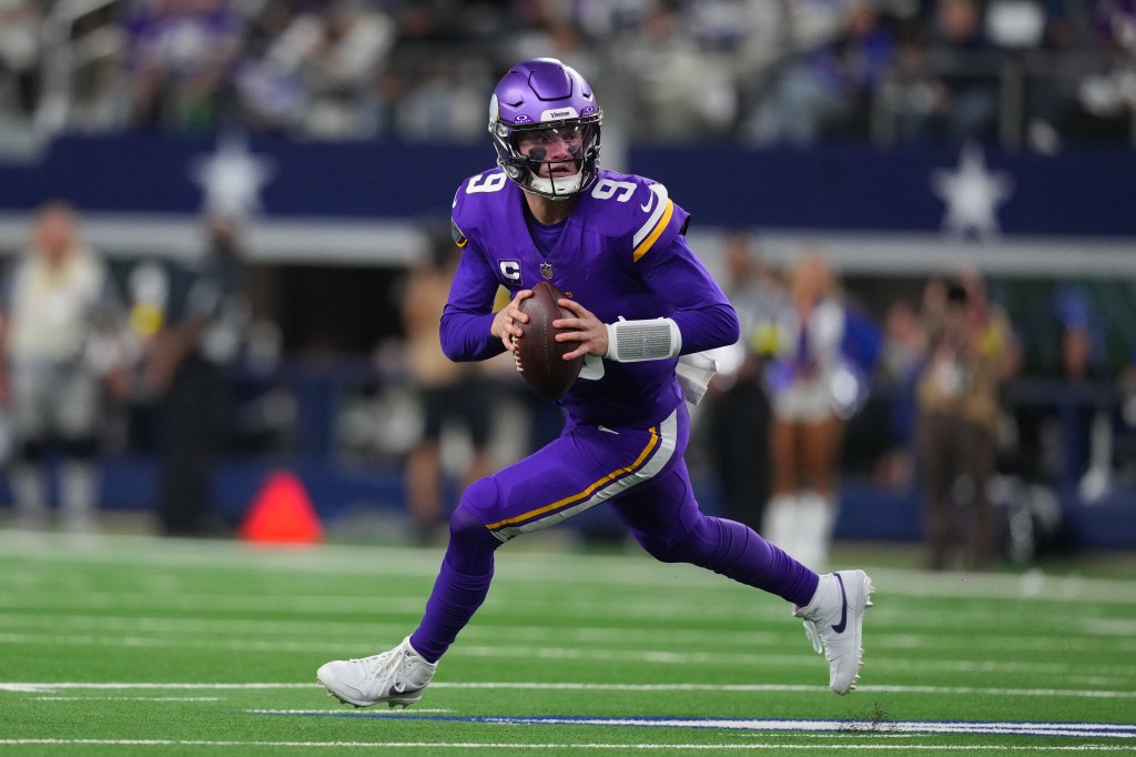 Minnesota Vikings quarterback J.J. McCarthy scrambling with the football.
