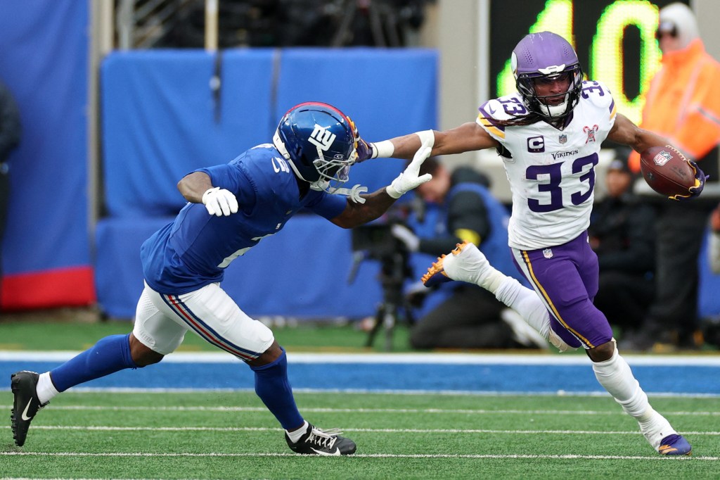 Vikings running back Aaron Jones (33) rushes the ball past Giants cornerback Deonte Banks (2) during the second half on Dec. 21, 2025.