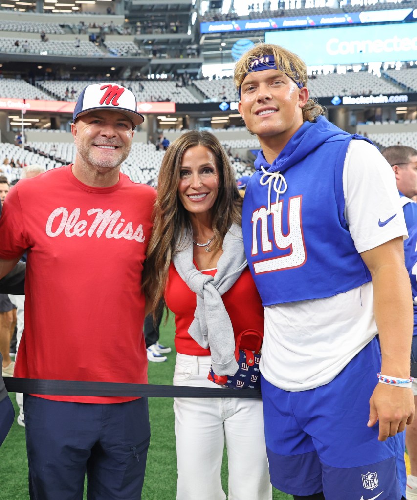 New York Giants quarterback Jaxson Dart and his parents Brandon and Kara Dart on the field before a game.