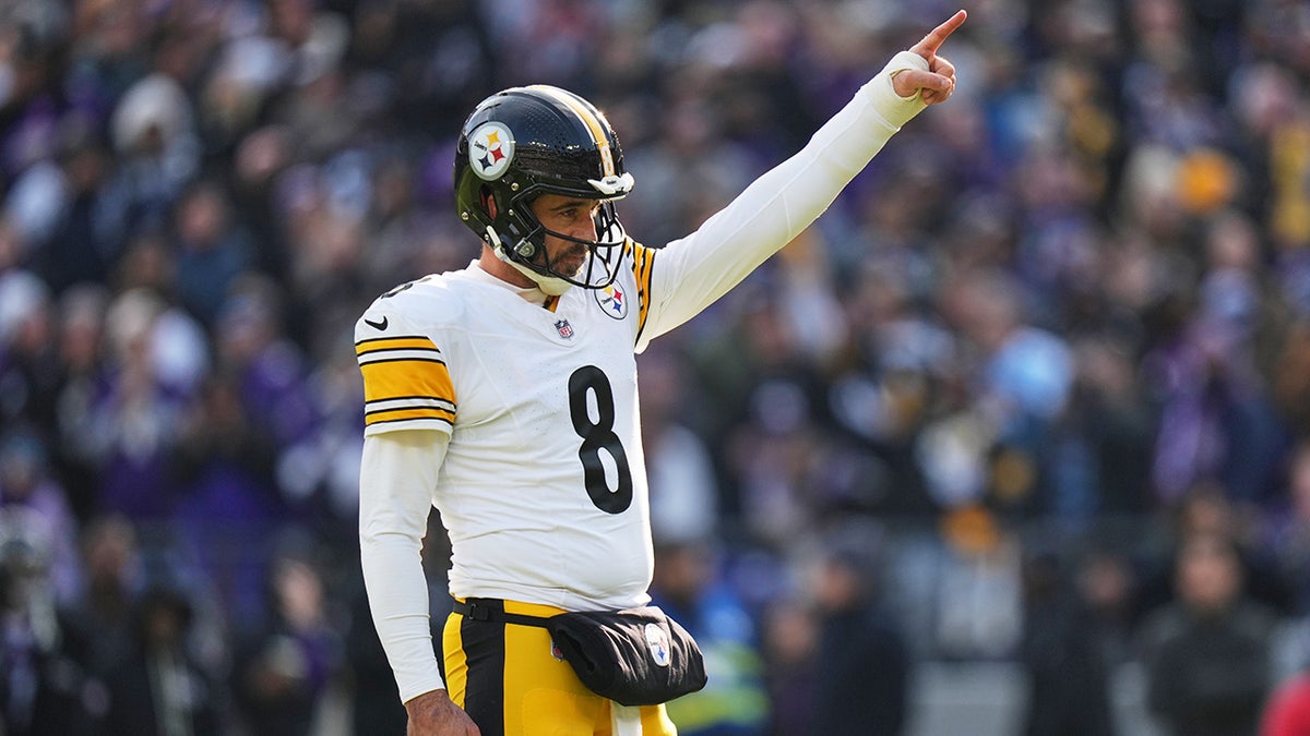 Aaron Rodgers points down the field