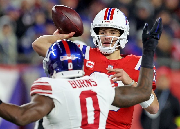 New England Patriots quarterback Drake Maye (10) throws over the head of Brian Burns of the New York Giants during the second half of a NFL game at Gillette Stadium. (Photo By Matt Stone/Boston Herald)