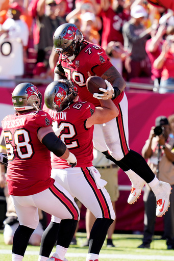 Tampa Bay Buccaneers offensive tackle Tristan Wirfs (78) celebrates his touchdown catch against the Arizona Cardinals with Buccaneers center Graham Barton (62) and Buccaneers guard Ben Bredeson (68) during the first half of an NFL football game Sunday, Nov. 30, 2025, in Tampa, Fla. (AP Photo/Chris O