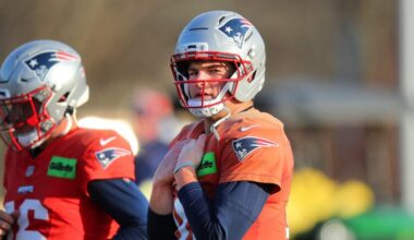 The NE Patriots practiced on their practice field at Gillette Stadium. QB Drake Maye walks along the field during stretching.