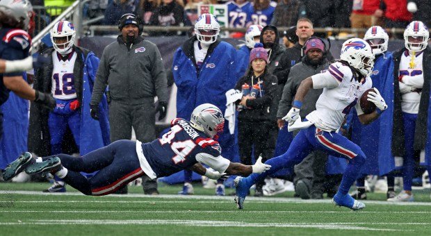 New England Patriots defender K'Lavon Chaisson dives for Buffalo Bills running back James Cook III during the second quarter. (Nancy Lane/Boston Herald)