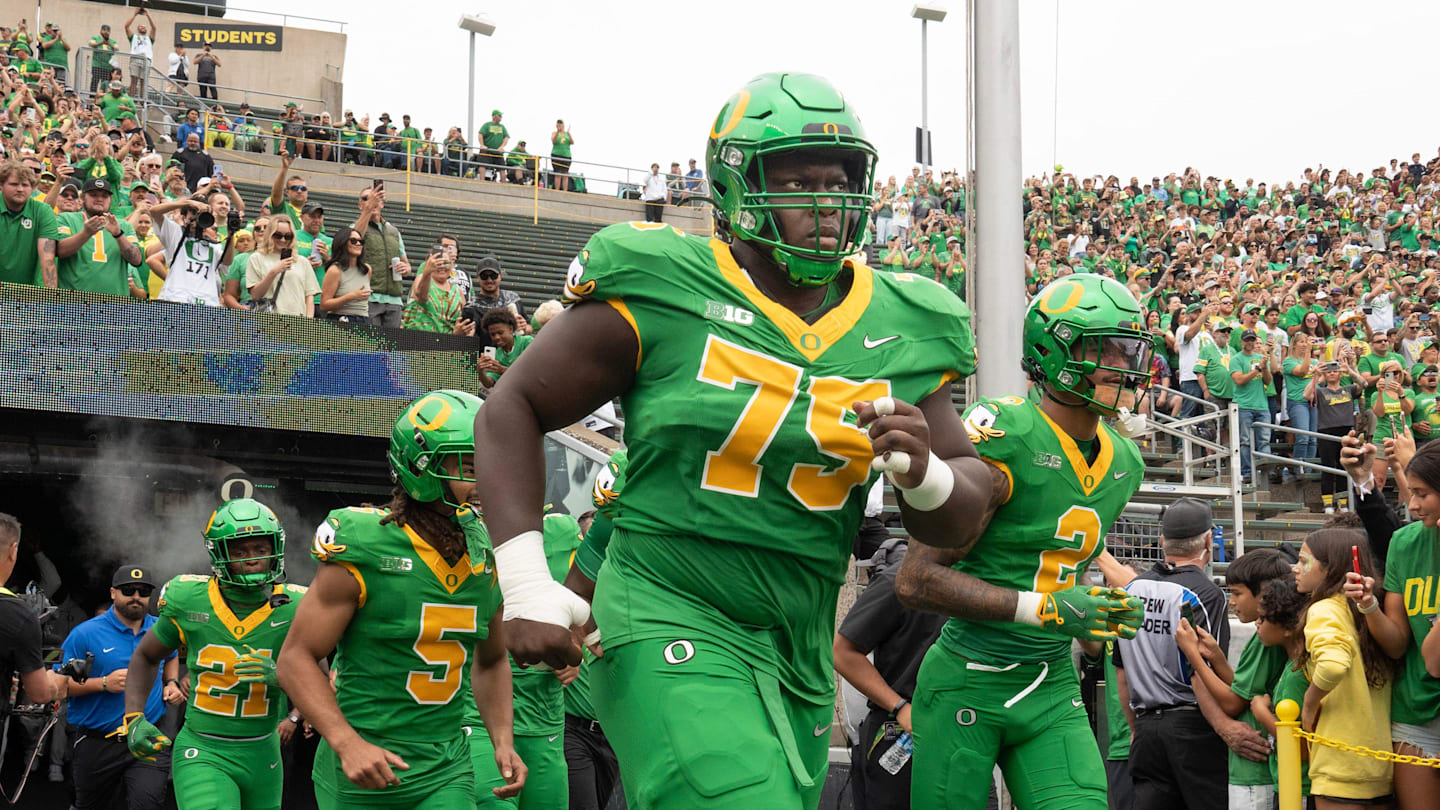 Oregon’s Emmanuel Pregnon, center, takes the field before the game against Oklahoma State at Autzen.