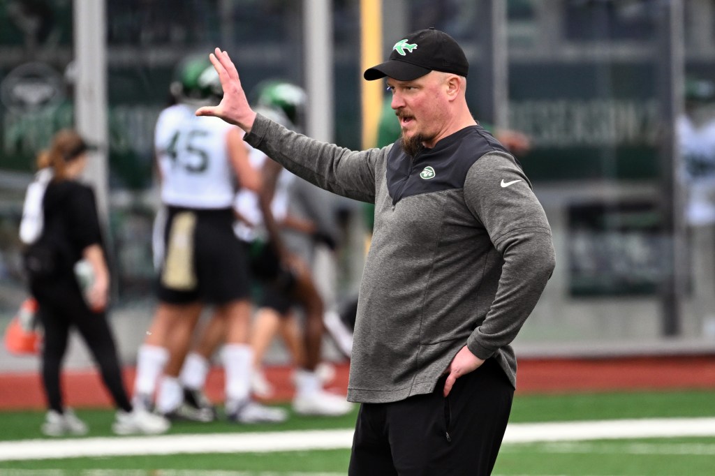 A New York Jets coach gestures on the sideline.