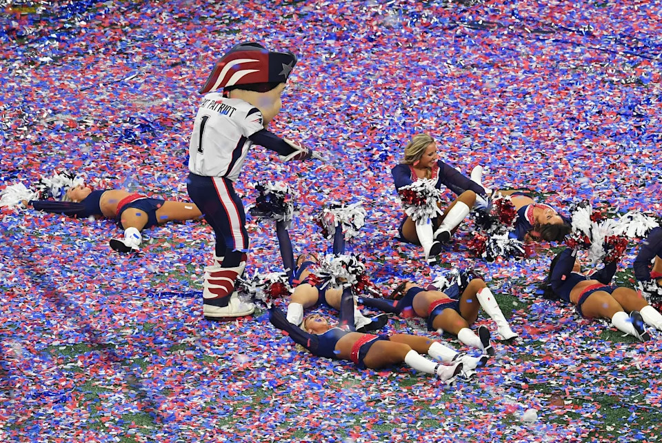 The New England Patriots mascot and cheerleaders celebrate in confetti.