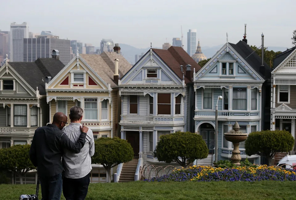 People stop to look at San Francisco's famed Painted Ladies Victorian houses on Feb. 18, 2014.