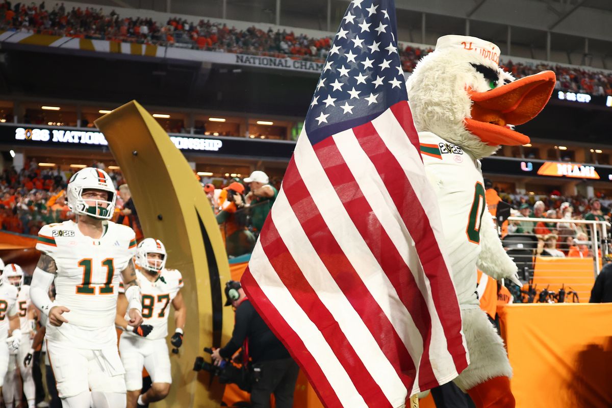 The Miami Hurricanes mascot Sebastian holds an American flag