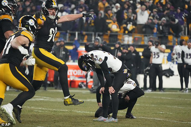 A dejected Loop pictured on the field after missing the kick - as the Steelers celebrated wildly