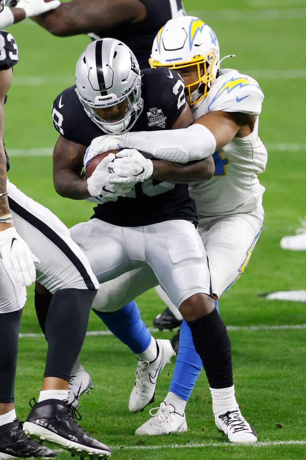 LAS VEGAS, NEVADA - DECEMBER 17: Running back Josh Jacobs #28 of the Las Vegas Raiders is tackled by outside linebacker Kyzir White #44 of the Los Angeles Chargers during the first half at Allegiant Stadium on December 17, 2020 in Las Vegas, Nevada. (Photo by Christian Petersen/Getty Images)
