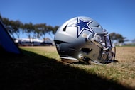 A Dallas Cowboys defensive players helmet is pictured on the sideline during a mock game...