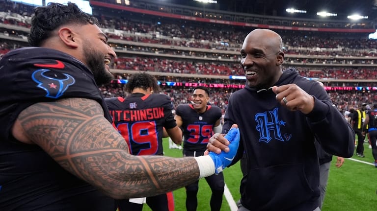 Houston Texans defensive tackle Tommy Togiai, left, celebrates his touchdown...