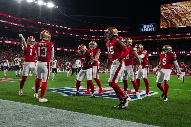 Teammates approach San Francisco 49ers starting quarterback Brock Purdy (13) as he celebrates in the end zone after scoring a touchdown in the first quarter of their NFL game at Levi's Stadium in Santa Clara, Calif., on Sunday, Dec. 28, 2025. (Jose Carlos Fajardo/Bay Area News Group)