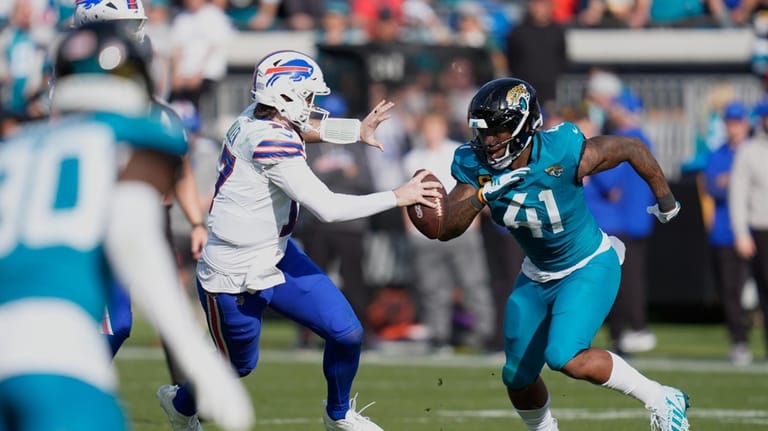 Buffalo Bills quarterback Josh Allen, center, scrambles as Jacksonville Jaguars...