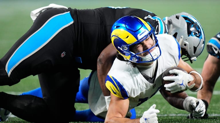 Los Angeles Rams wide receiver Puka Nacua, bottom, is tackled...