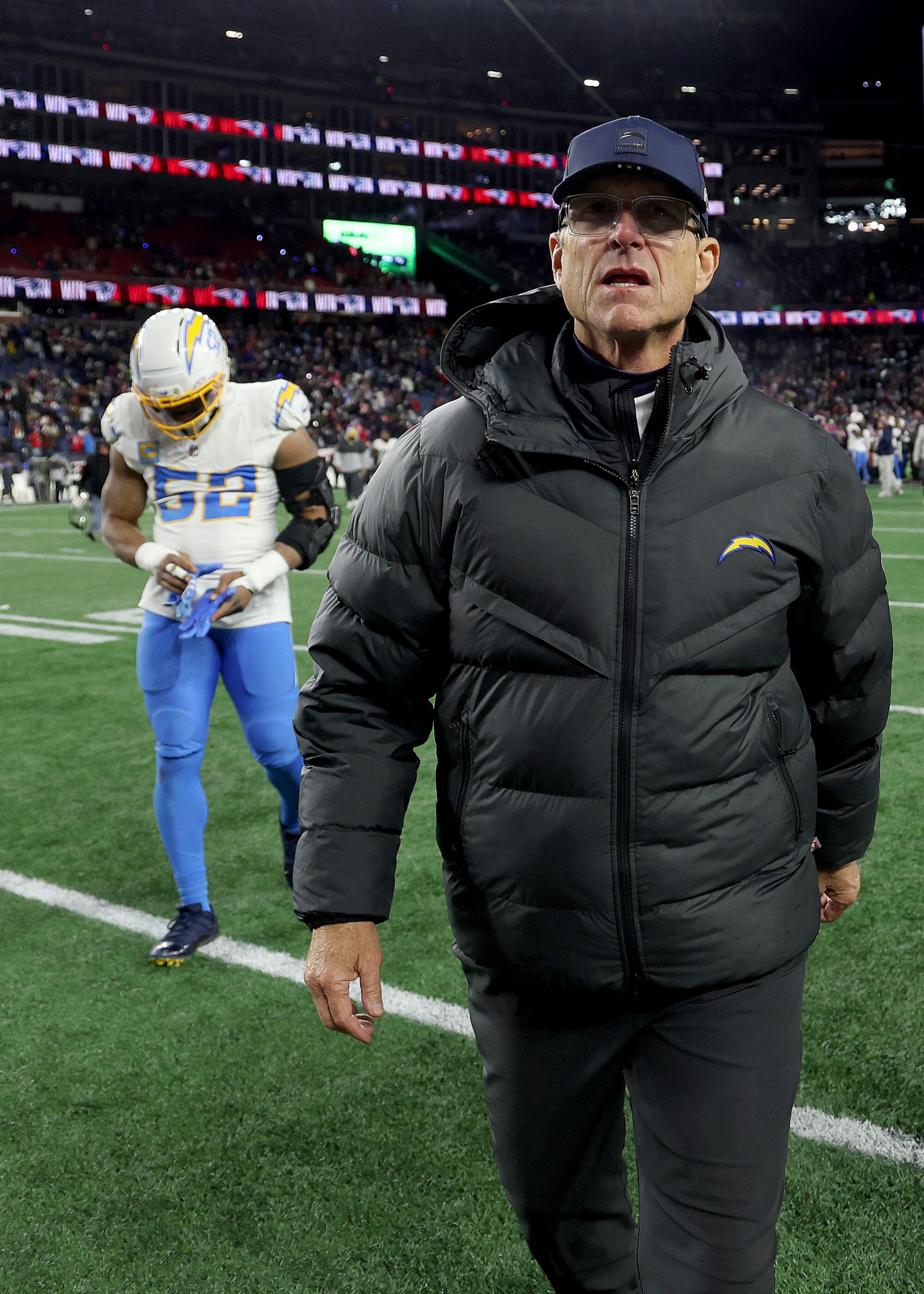 Chargers coach Jim Harbaugh walks of the field after a 16-3 loss to the Patriots in the AFC wild-card playoffs Sunday.